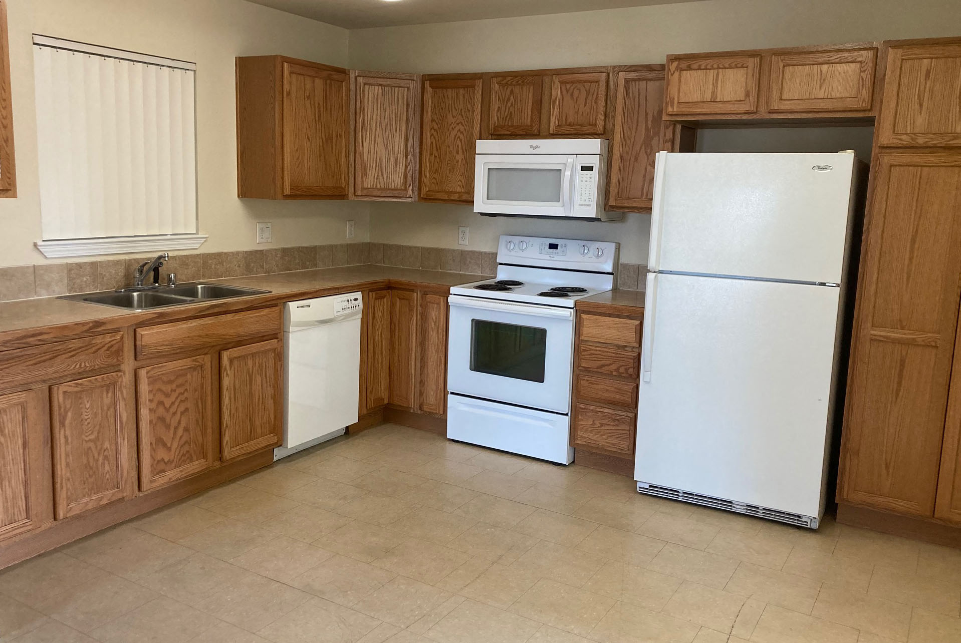 a kitchen with white appliances and wooden cabinets